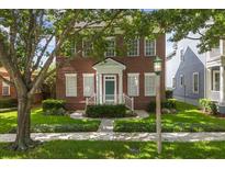 Charming two-story brick home with a well-manicured lawn and lovely green door at 704 Honeysuckle Ave, Kissimmee, FL 34747