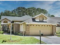Charming single-story home featuring an attached two-car garage with a well maintained lawn and mature trees at 724 Barrington Cir, Winter Springs, FL 32708
