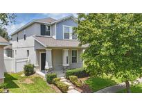 Charming two-story home with a well-manicured front yard and covered porch with stone pillar accents at 10172 Storey Grove Way, Winter Garden, FL 34787