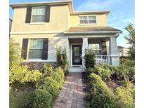 Charming two-story home with manicured landscaping and inviting front porch at 11982 Travel Aly, Orlando, FL 32832