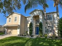 Attractive two-story home with a well-maintained lawn, stucco facade, and lush landscaping at 1208 Castleport Rd, Winter Garden, FL 34787