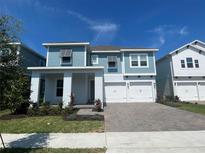Charming two-story home featuring a two-car garage and a beautifully landscaped front yard under a bright sky at 13075 Sunrise Harvest Dr, Winter Garden, FL 34787