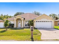 Charming single-story home with a well-manicured lawn, two-car garage, and inviting front entrance at 1321 Dunbarton Ct, Kissimmee, FL 34758