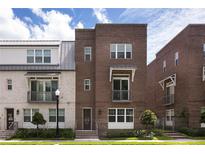 Beautiful brick townhome featuring a landscaped front yard, small balcony, and stylish modern design at 141 S. Park Ave, Winter Garden, FL 34787