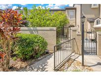 Inviting front entrance with stucco wall, mature landscaping, and secure gated access at 1525 Farrindon Cir, Lake Mary, FL 32746