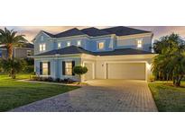 Two-story home featuring a driveway, lawn and a three-car garage at 16086 Johns Lake Overlook Dr, Winter Garden, FL 34787