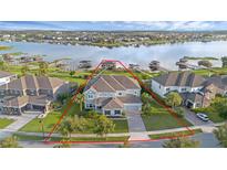 Stunning lakefront home boasts lush landscaping, mature trees, and a private waterfront setting perfect for entertaining at 16086 Johns Lake Overlook Dr, Winter Garden, FL 34787