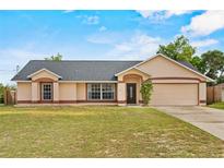 Charming single-story home featuring a well-manicured lawn and a two-car garage at 2311 Alton Rd, Deltona, FL 32738