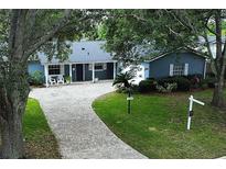 Charming single-story blue home with a brick driveway and well-maintained landscaping at 2318 Mohawk Trl, Maitland, FL 32751