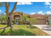 Charming single-story home with a well-manicured lawn, beautiful landscaping, and a two-car garage at 4047 Lillian Hall Ln, Orlando, FL 32812