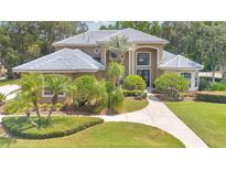 Beautiful two story home featuring a blue tiled roof, green lawn, and well maintained landscaping at 4052 Gilder Rose Pl, Winter Park, FL 32792