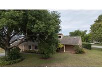 Inviting single-Gathering home featuring an attached two-car garage and lush landscaping, creating a welcoming curb appeal at 6047 Shore Line Dr, Orlando, FL 32819