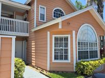 Charming two-story home featuring unique architectural windows, a balcony, and well-maintained landscaping at 8704 Knightsbridge Ct # B, Kissimmee, FL 34747