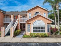Charming two-story condo with a well-manicured lawn and inviting entrance, nestled in a vibrant, sunny locale at 8704 Knightsbridge Ct # B, Kissimmee, FL 34747