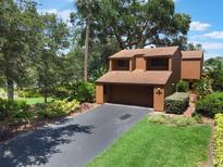 Two-story house with attached garage, well-manicured lawn and lots of surrounding trees at 105 Oaks Ct, Sanford, FL 32771
