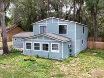 Charming two-story home featuring light blue siding, white trim, and a well-maintained yard surrounded by mature trees at 1288 Se 32Nd St, Ocala, FL 34471