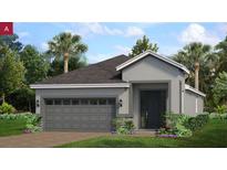 Charming single-story home with gray exterior, a two-car garage, and tropical landscaping in a sunny neighborhood at 152 Fredericksburg Ave, Orange City, FL 32763
