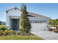 Charming single-Gathering home featuring a two-car garage, minimalist landscaping, and a modern front door at 152 Fredericksburg Ave, Orange City, FL 32763