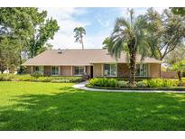 Charming one-story home featuring a well-manicured lawn and lush landscaping at 1600 N Wind Ct, Winter Springs, FL 32708
