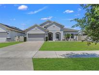 Charming single-story home featuring a well-manicured lawn and attached two-car garage, bathed in bright sunlight at 1821 Benevento St, St Cloud, FL 34771
