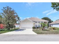Charming single-story home with a well-manicured lawn and an attached two-car garage at 214 Glasgow Ct, Davenport, FL 33897