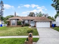 Charming single-Gathering home features a manicured lawn and attached two-car garage at 2203 Essex Dr, Ocoee, FL 34761