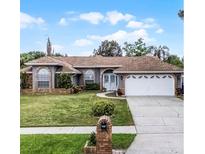 Charming single-story home featuring a well-maintained lawn, brick accents, and a two-car garage at 2203 Essex Dr, Ocoee, FL 34761