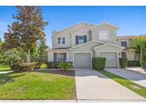 Charming townhome featuring a two-car garage, well-manicured lawn, and inviting curb appeal at 2488 Hassonite St, Kissimmee, FL 34744