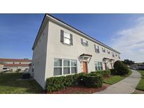 Two-story townhome with manicured shrubs and landscaping at 3128 Camino Real N Dr, Kissimmee, FL 34744