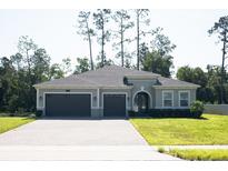 Beautiful home featuring a three car garage and a well-manicured lawn at 5161 Kingwell Cir, Oviedo, FL 32765