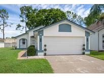 Charming single-story home features a two-car garage, landscaped yard, and freshly painted white and blue exterior at 5729 Norman H Cutson Dr, Orlando, FL 32821