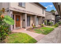 Inviting townhome featuring a well-maintained facade with a charming front garden and brick pathway at 658 Lake Villas Dr, Altamonte Springs, FL 32701