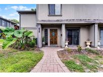 Inviting townhome front entrance with a brick path and a beautifully carved wooden door at 658 Lake Villas Dr, Altamonte Springs, FL 32701