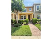 Charming townhouse with a brick pathway, well-maintained lawn, and inviting front porch at 7629 Ripplepointe Way, Windermere, FL 34786