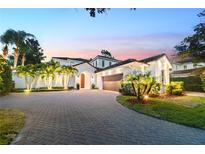 Beautiful home with a herringbone brick drive, lush landscaping, and an attached garage at 9743 Covent Garden Dr, Orlando, FL 32827
