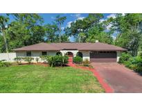 Charming single-story home boasts a well-manicured lawn and inviting curb appeal with lush landscaping at 102 Ichabod Trl, Longwood, FL 32750