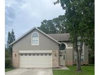 Charming two-story home featuring an attached two-car garage, brick accents, and a well-manicured front lawn at 11218 Green Heron Ct, Orlando, FL 32825