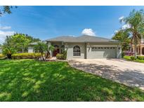 Charming single-story home featuring a well-manicured lawn, beautiful landscaping, and a two-car garage at 13108 Lakeshore Grove Dr, Winter Garden, FL 34787