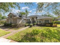 Charming home featuring mature trees, lush green lawn, and manicured shrubs at 2046 Westover Reserve Blvd, Windermere, FL 34786