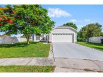 Charming single-story home featuring a well-manicured lawn and an attached two-car garage at 2301 Finwick Ct, Kissimmee, FL 34743