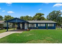 Charming single-story home with a well-maintained lawn and covered carport with a lovely blue exterior at 2904 Allison Dr, Orlando, FL 32826