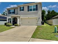 Charming two-story home with a well-maintained lawn and attached two-car garage at 6780 Coral Berry Dr, Mount Dora, FL 32757