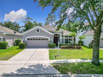 Beautiful home featuring a two-car garage, manicured lawn, and lovely landscaping at 10875 Arbor View Blvd, Orlando, FL 32825