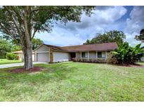 Charming single-story home with stone accents, attached garage, and a well-manicured front lawn at 126 Ingram Cir, Longwood, FL 32779
