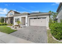 Well-maintained single Gathering home with a brick paver driveway and beautiful landscaping at 14366 Alafaya Oak Bnd, Orlando, FL 32828