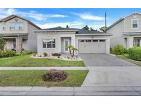 Charming single-story home featuring a well-manicured lawn and inviting two-car garage at 14366 Alafaya Oak Bnd, Orlando, FL 32828