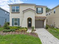 Charming two-story home featuring a well-maintained yard, neutral paint, and an attached one-car garage at 1999 Tropical Palms Cir, Kissimmee, FL 34747