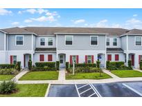 Charming townhome exterior with landscaped front yard and red shutters at 228 Primrose Dr, Davenport, FL 33837