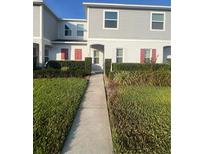 Charming townhome with a well-manicured lawn and landscaped entryway at 228 Primrose Dr, Davenport, FL 33837