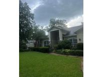 Charming single-story home featuring a well-manicured lawn and lush landscaping at 2435 Sweetwater Country Club Dr, Apopka, FL 32712